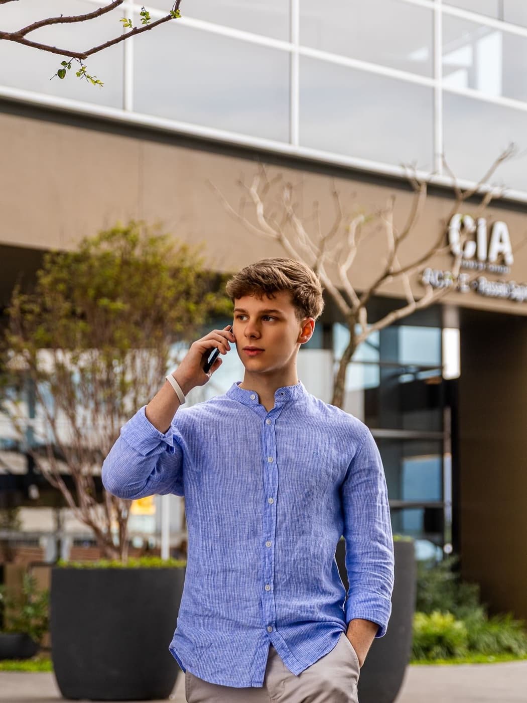 Aluno da Winners falando ao telefone na frente de um prédio comercial
